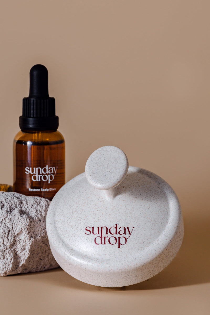 Sunday Drop skincare products including a bottle and a stone on a beige background